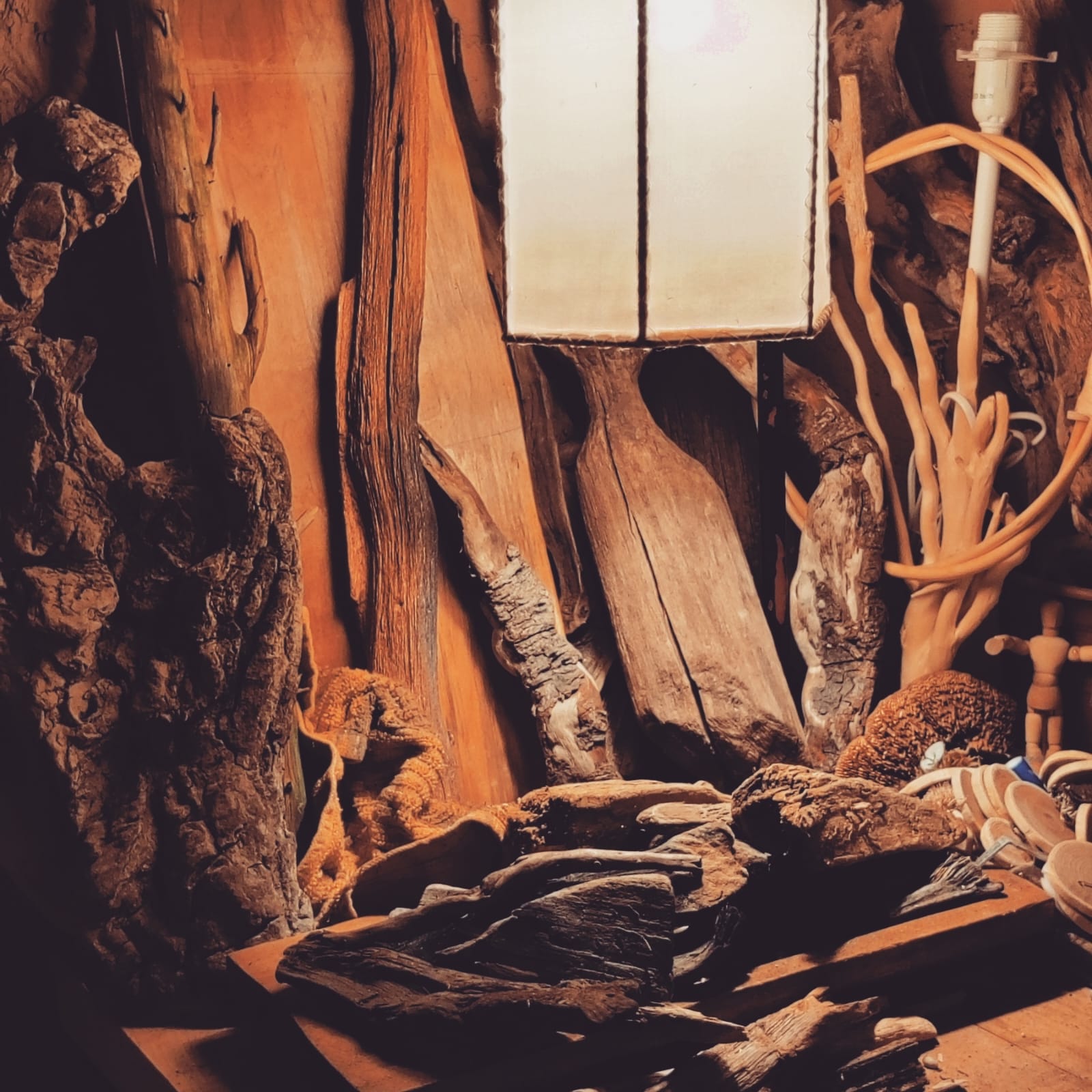 Intérieur de l'atelier Sarah La Sauvage – bois flotté et cœur de chêne empilés, matières premières pour lampes artisanales